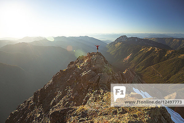 Entfernte Ansicht eines Bergsteigers auf dem Gipfel des Tomyhoi Peak