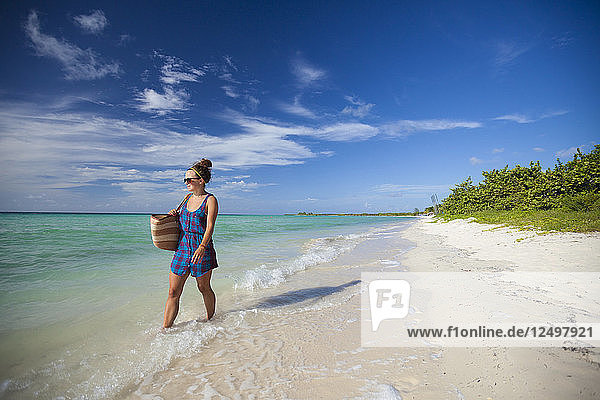 Eine junge Frau spaziert an einem Strand in Cayo Coco  Kuba  entlang.