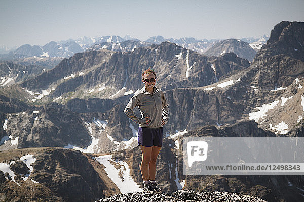 Portrait of a fit young woman standing on the summit of Lakeview Mountain in Cathedral Lakes Provincial Park  British Columbia  Canada.