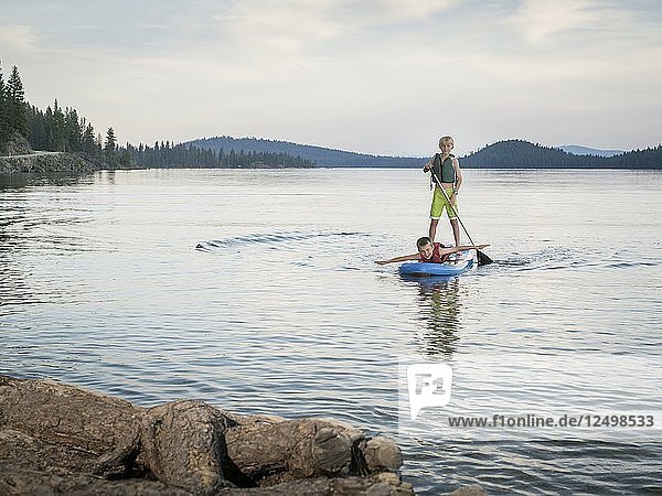 Young Boys Having Fun Paddling On Paddleboard In Payette Lake