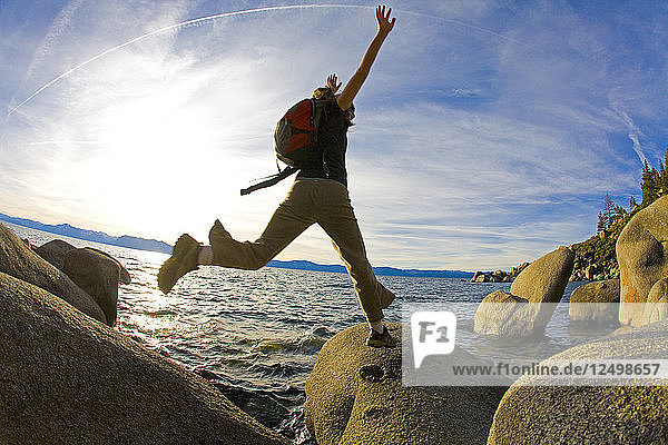 Woman Jumping On Rock In Lake Tahoe