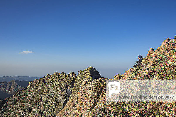 Ein Mann genießt das Morgenlicht auf dem Gipfel des Nord-Eolus