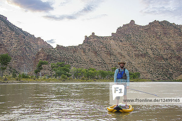 Standup paddleboarder in Desolation Canyon along the Green River  Utah.
