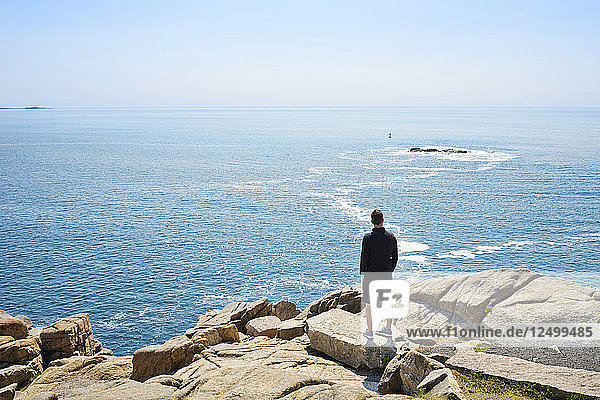 Mann steht auf Otter Point und blickt auf den Atlantik  Acadia National Park  Maine