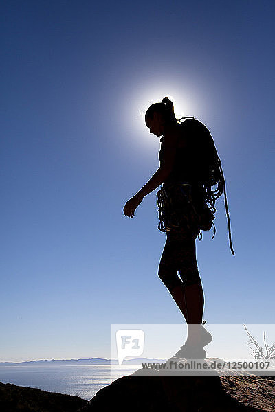 A female climber walks off of Lower Gibraltar Rock in Santa Barbara  California. Lower Gibraltar Rock provides great vistas of Santa Barbara and the Pacific Ocean.