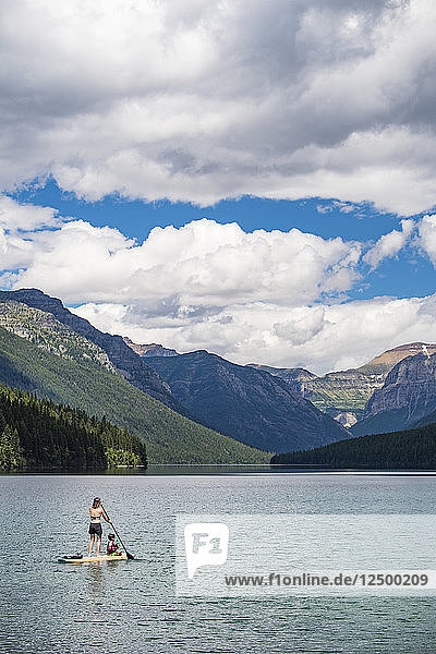 Frau paddelt mit Kind auf dem Bowman Lake im Glacier National Park