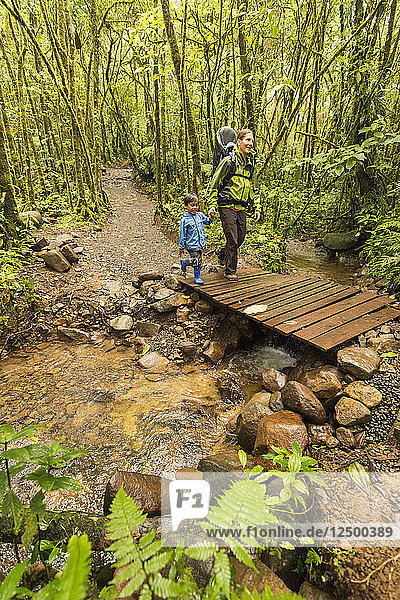 Mutter und Sohn wandern durch den costaricanischen Regenwald auf dem Weg zum Rio Celeste