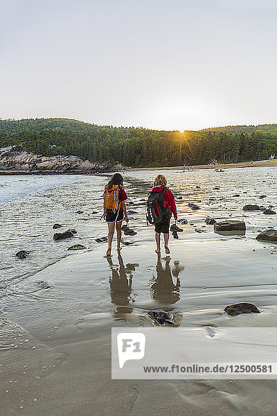 Rückansicht von Teenager-Junge und Mädchen zu Fuß auf Sand Strand