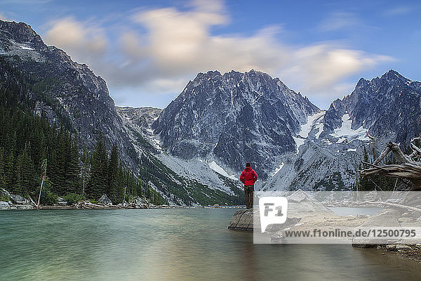 Ein Mann steht und beobachtet am Dragontail Peak  Colchuck Lake