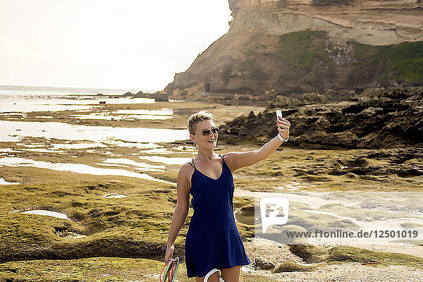 Woman taking selfie on coastline