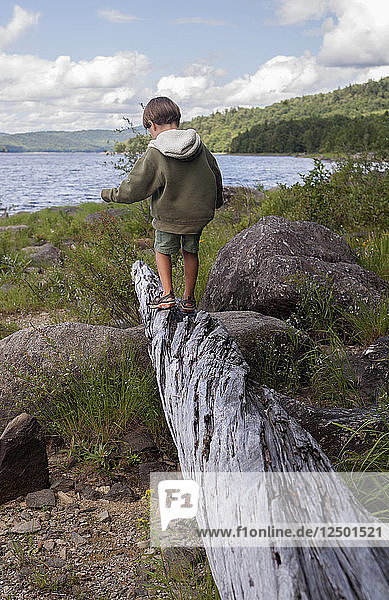 A four-year-old boy plays by Black Bear Cove on Aziscohos Lake in Lincoln Plantation  Maine . Photo by Laurie Swope