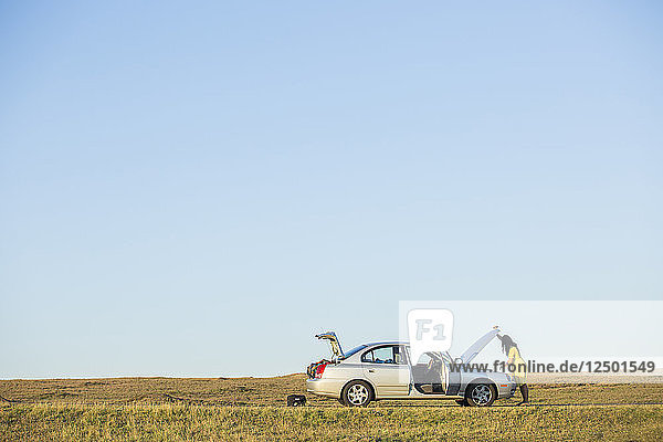 Eine erwachsene Frau  die in der Mitte von North Dakota mit Autoproblemen festsitzt