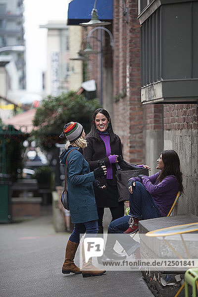 Suzanne Waldrup  Katie Cox und Brooke LaFave treffen sich in der Post Alley von Seattle. Washington.