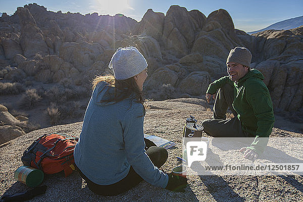 Couple resting with coffee while hiking in Alabama Hills