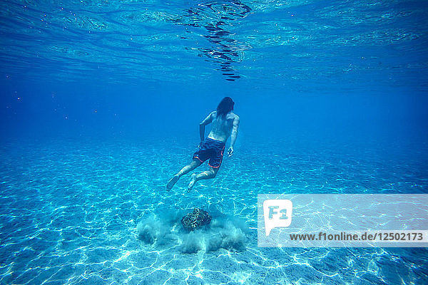 Man swimming underwater.