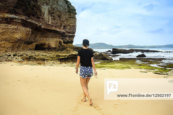 Woman walking on sandy beach