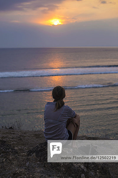 Frau betrachtet den Sonnenuntergang im Meer.West Sumbawa.Indonesien.
