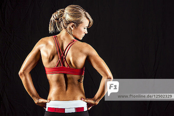 Woman With Strong Back Muscles And Hands On Hips With Back Facing Camera