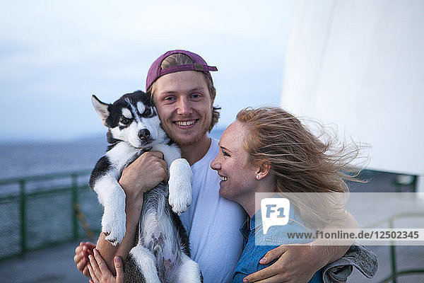 Junge Erwachsene und Husky-Welpe auf einer Fähre