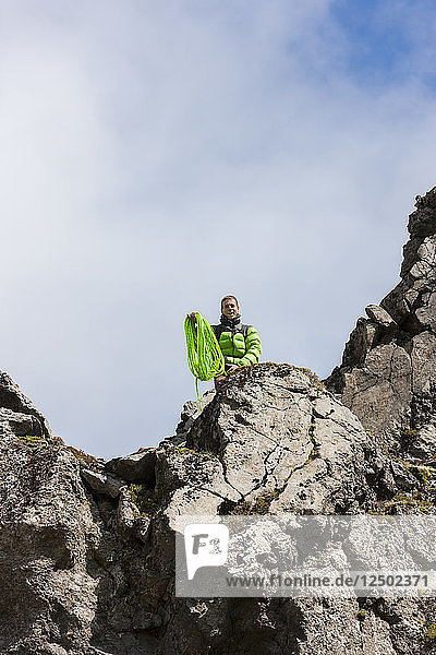 Climber throwing a rope off a cliff before a rappel. Hnappavellir  Iceland.