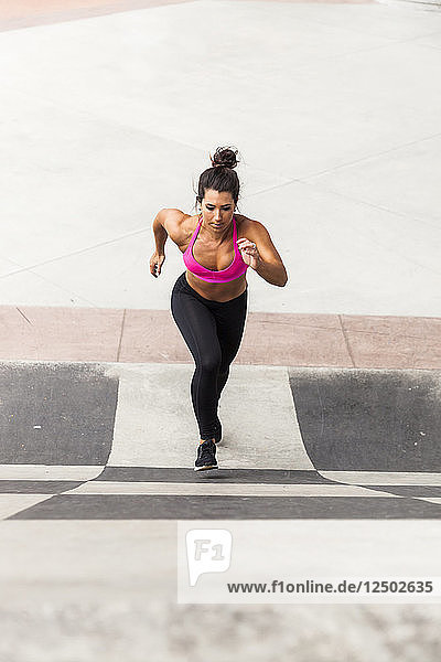 Fit Woman Running Up A Wall In The City Wearing Sports Bra