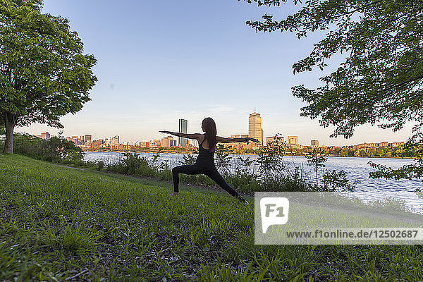 Yoga im Gras am Ufer des Charles River mit Blick auf die Skyline von Boston