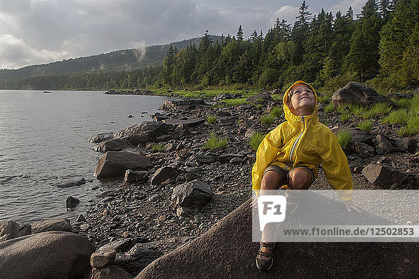 A six-year-old boy plays by Black Bear Cove on Aziscohos Lake in Lincoln Plantation  Maine .