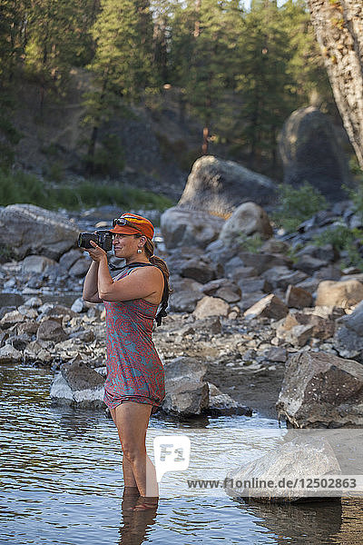 Eine Frau stellt sich in den Spokane River  um im Riverside State Park  Washington  Fotos zu machen.