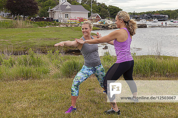 Yoga teacher assisting in warrior two pose