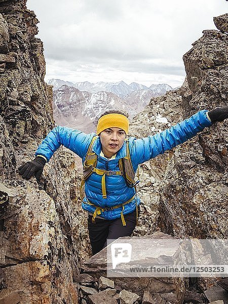 A Young Woman In A Blue Jacket Climbing A Mountain In Colorado  Usa
