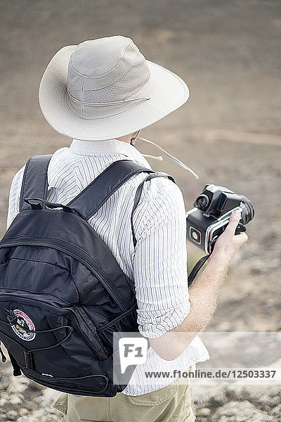 Rear View Of Man With A Camera In Hand
