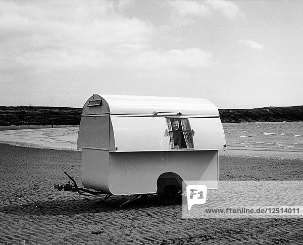 Woman smiling from the window of a trailer caravan on a beach  (c1960s?). Artist: Unknown