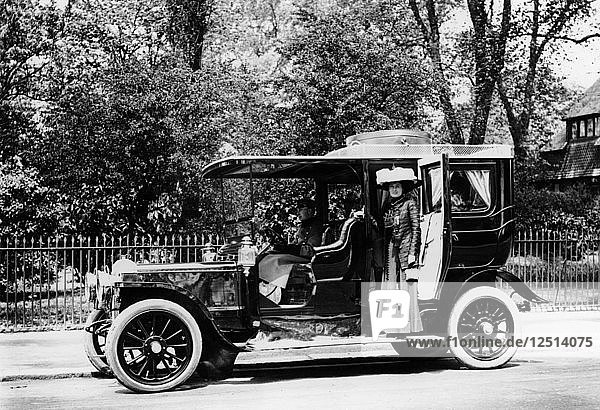 Frau steht neben einem Daimler von 1907/8. Künstler: Unbekannt