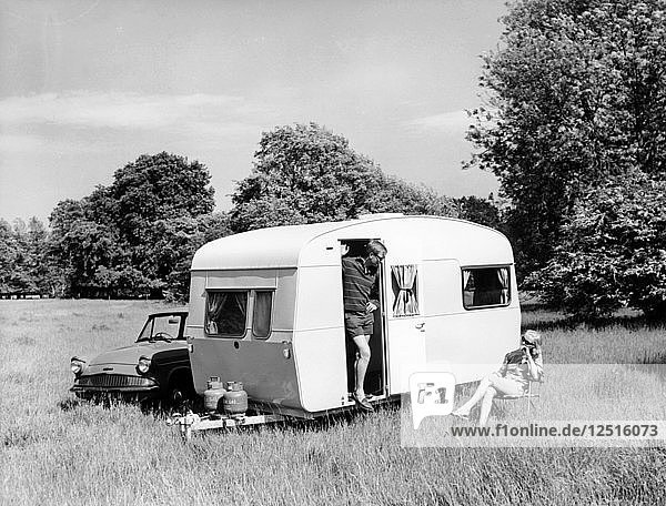 Ehepaar im Urlaub mit ihrem Wohnwagen Sprite Alpine von 1963  (um 1963?). Künstler: Unbekannt