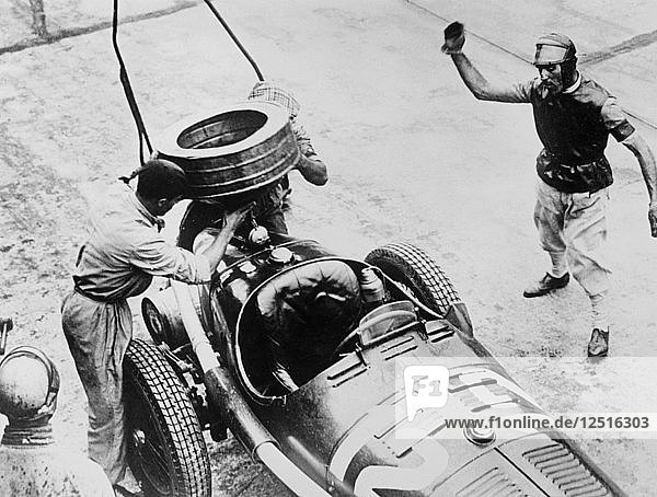 Tazio Nuvolari waiting for his car to be refuelled  c1930s(?). Artist: Unknown