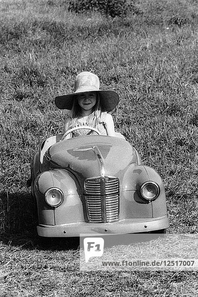 Girl in a 1948 vintage Austin J40 pedal car. Artist: Unknown