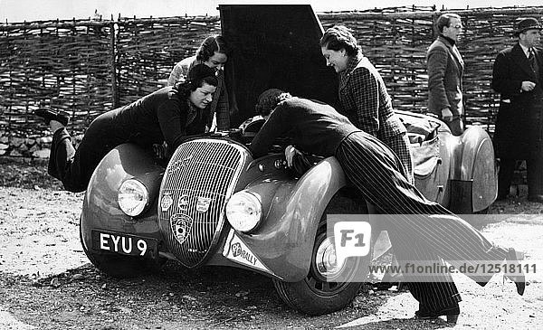 Miss MD Patten looking at the engine of a 1938 Peugeot 402 Special Sport  RAC Rally  1939. Artist: Unknown