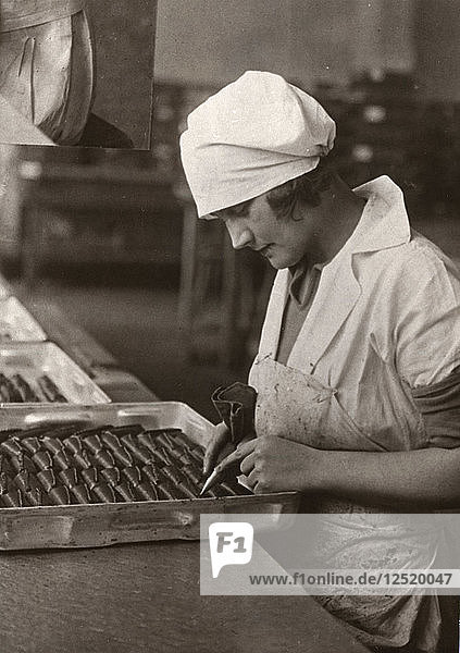 Eine Frau benutzt einen Spritzbeutel zum Verzieren von Pralinen  Rowntree-Fabrik  York  Yorkshire  1932. Künstler: Unbekannt