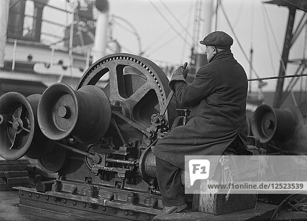 A docker operates a winching gear in London Docks  London  c1945-c1965. Artist: SW Rawlings