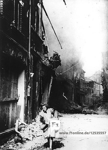 Eine Frau verlässt ihr brennendes Haus in einer zerbombten Straße  Deutschland  1945. Künstler: Unbekannt