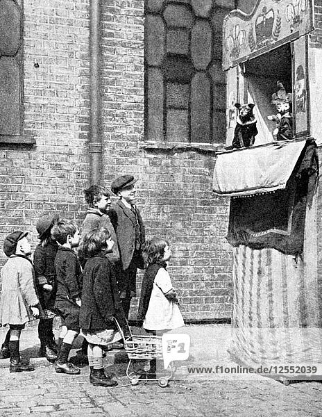 Kinder sehen sich ein Kasperletheater in einer Londoner Straße an  1936. Künstler: Donald McLeish