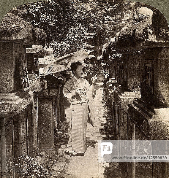A woman Shinto devotee counting the stone lanterns  Kasuga Shrine  Nara  Japan  1904.Artist: Underwood & Underwood