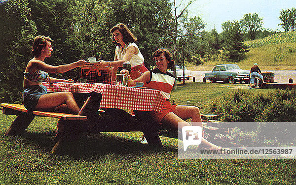 Drei junge Frauen an einem Picknicktisch  die eine Mahlzeit genießen  Snowdon  Montreal  Kanada  1955. Künstler: Unbekannt