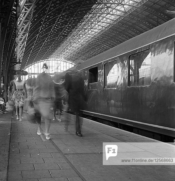 Reisende  die einen Bahnsteig in der Centraal Station entlanggehen  Amsterdam  Niederlande  1963. Künstler: Michael Walters