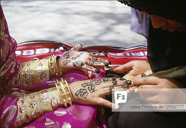 Geometric and floral decorative henna patterns were applied to adorn the hands and feet of young women on occasions such as weddings.