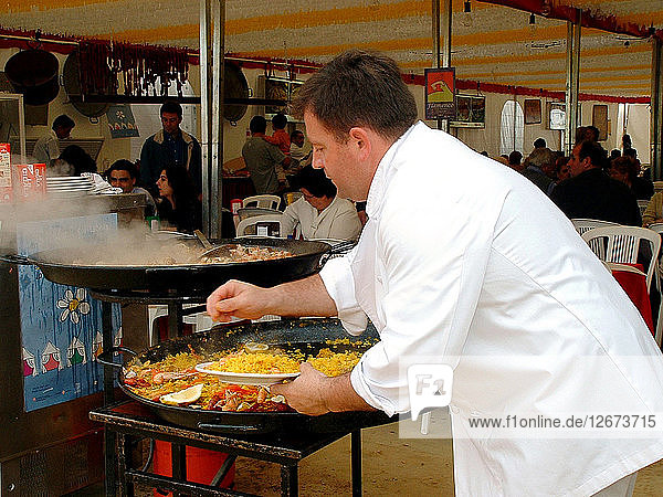 Mediterranean cuisine chef preparing a paella Feria de Abril (April Fair) 2002.