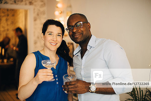 Portrait of multi-ethnic friends enjoying drinks in party at home