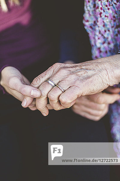 Cropped image of grandmother and granddaughter holding hands