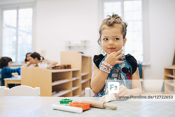 Girl playing with toys at table in child care classroom