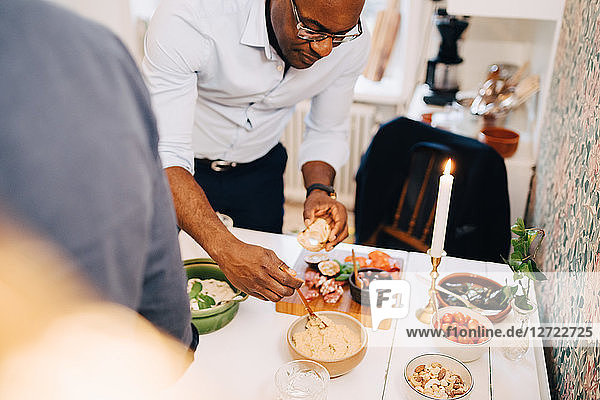 Mature man having food at dining table in party